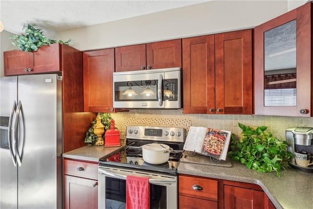 kitchen with backsplash, dark brown cabinets, appliances with stainless steel finishes, and a textured ceiling