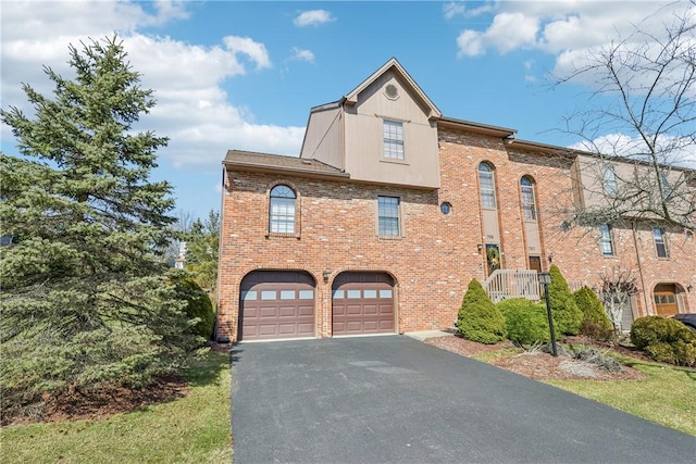 view of front facade featuring brick siding, aphalt driveway, and a garage