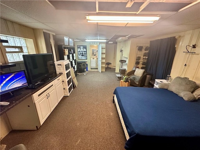 bedroom featuring a paneled ceiling and dark colored carpet