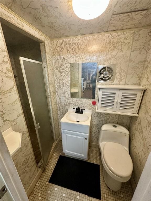 bathroom featuring wallpapered walls, a shower stall, toilet, and vanity