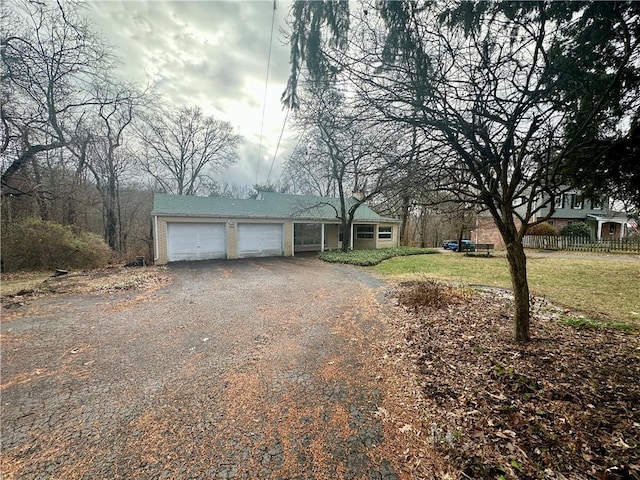 exterior space featuring driveway, a front yard, and a garage