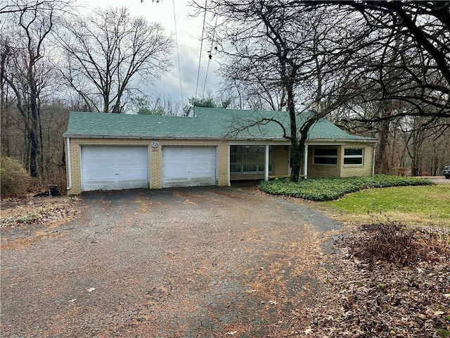 ranch-style house with brick siding, driveway, and an attached garage