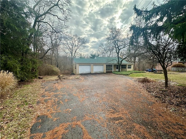 view of front of property featuring aphalt driveway and a garage