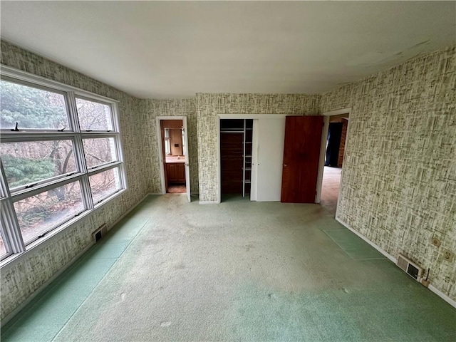 unfurnished bedroom with a closet and visible vents