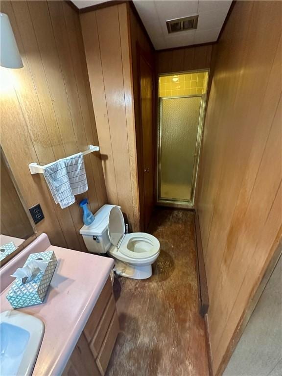 bathroom featuring visible vents, toilet, a stall shower, a sink, and wood walls