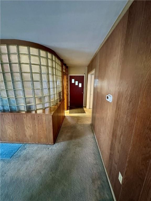 corridor featuring carpet flooring and wood walls