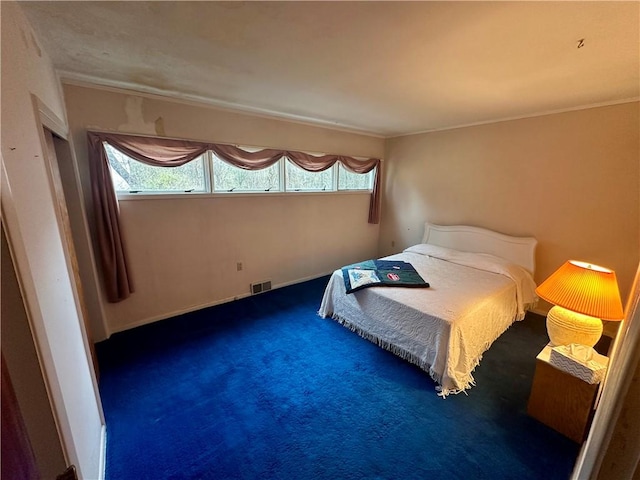 unfurnished bedroom featuring visible vents, multiple windows, carpet flooring, and baseboards