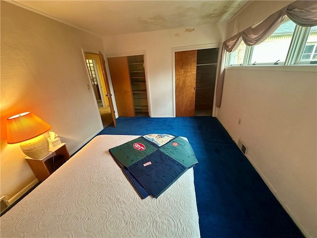 bedroom with visible vents, carpet floors, and baseboards