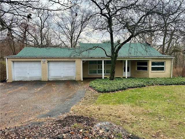 ranch-style home with a front lawn, driveway, roof with shingles, a garage, and brick siding