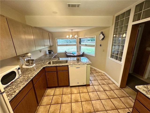 kitchen with visible vents, dishwasher, a peninsula, light tile patterned flooring, and a sink