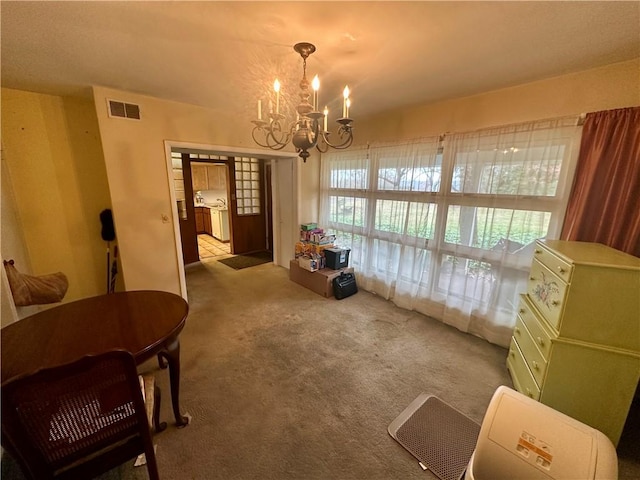 dining space with an inviting chandelier, carpet flooring, and visible vents