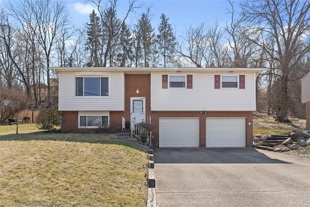 split foyer home featuring a front yard, brick siding, concrete driveway, and an attached garage