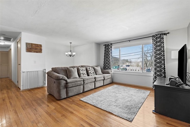 living room with visible vents, a notable chandelier, and light wood finished floors