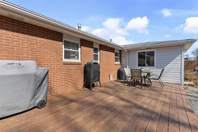 deck featuring outdoor dining area and a grill