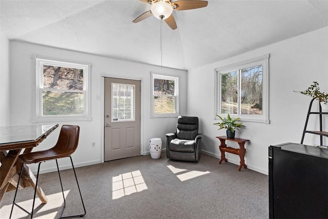 living area featuring a ceiling fan, vaulted ceiling, carpet, and baseboards