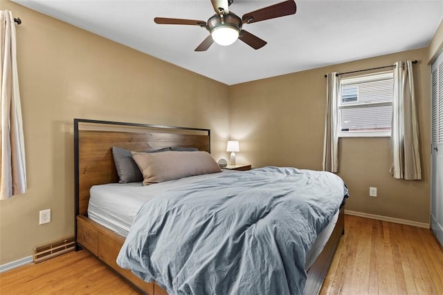 bedroom with visible vents, light wood-style flooring, baseboards, and ceiling fan