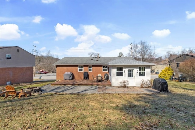 back of house with brick siding, a lawn, and a patio area