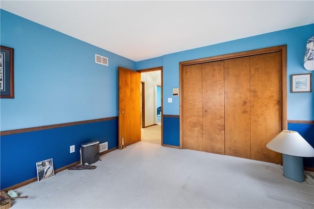 carpeted bedroom with a closet, visible vents, and baseboards