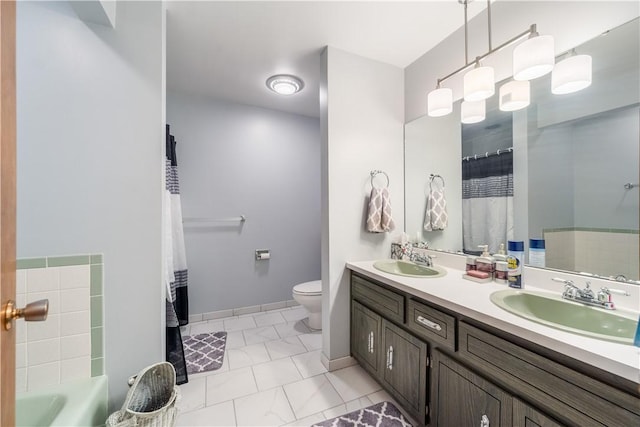 full bath featuring double vanity, toilet, baseboards, and a sink