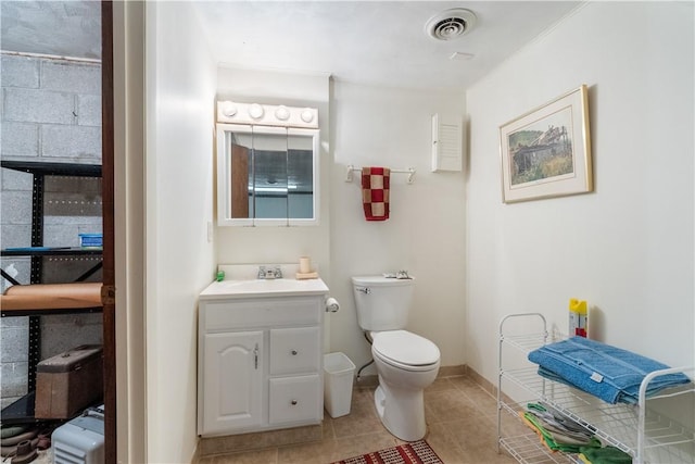 half bath with visible vents, toilet, tile patterned flooring, baseboards, and vanity