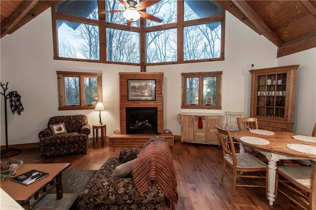 living room with beamed ceiling, wood finished floors, and a fireplace with raised hearth