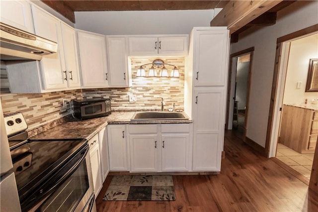 kitchen featuring a sink, under cabinet range hood, wood finished floors, white cabinetry, and appliances with stainless steel finishes