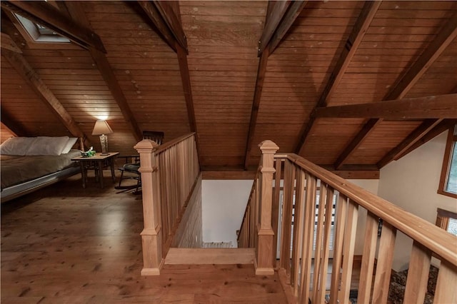 stairway with lofted ceiling with beams, wood finished floors, and wooden ceiling