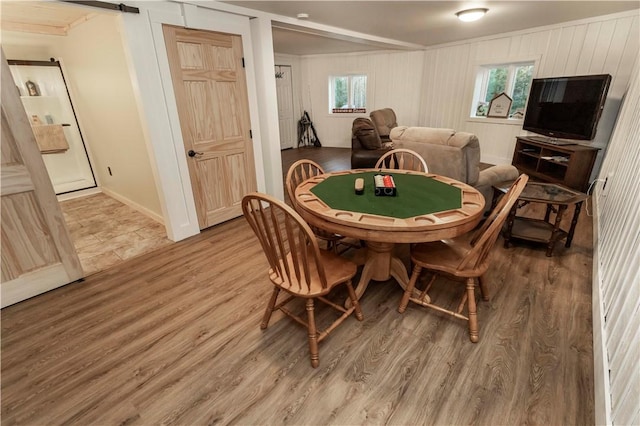 recreation room featuring plenty of natural light, a barn door, and wood finished floors