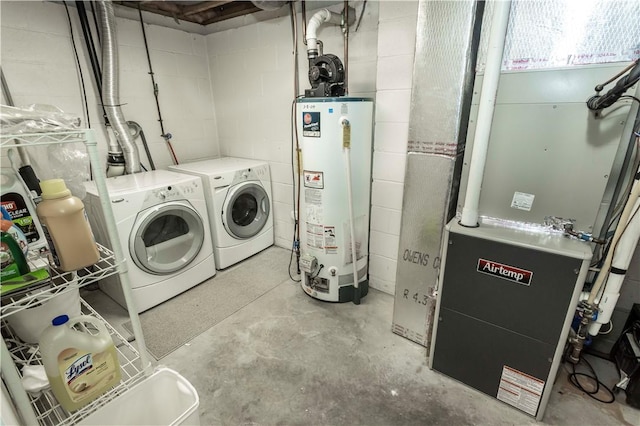 clothes washing area with washer and dryer, heating unit, concrete block wall, and water heater