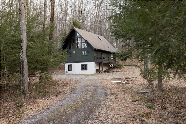 exterior space with a deck and dirt driveway