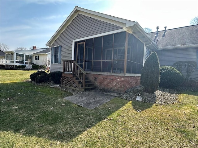 back of house featuring a yard and a sunroom