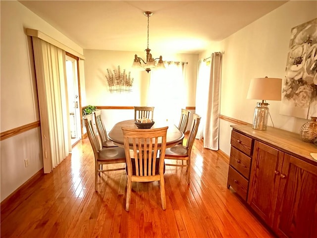 dining area with a notable chandelier and light wood-style floors