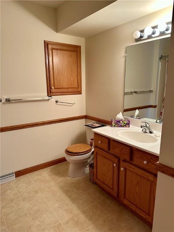 bathroom with vanity, toilet, visible vents, and baseboards