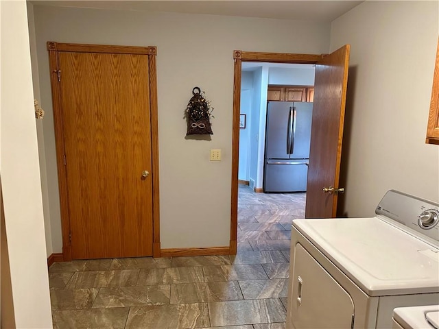 laundry room featuring laundry area, baseboards, and separate washer and dryer