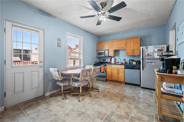 kitchen with ceiling fan, a sink, baseboards, and stainless steel appliances