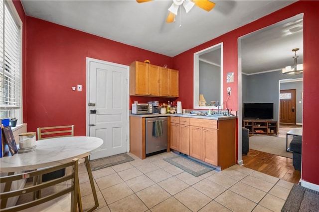 kitchen featuring ornamental molding, ceiling fan with notable chandelier, stainless steel dishwasher, open floor plan, and light tile patterned floors