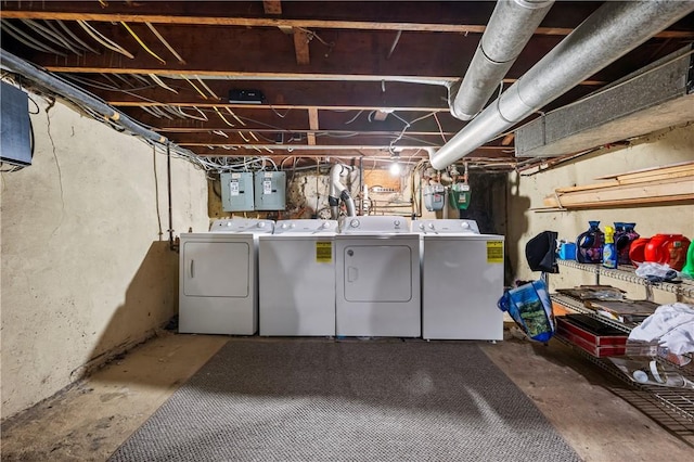 unfinished below grade area with electric panel and washer and clothes dryer