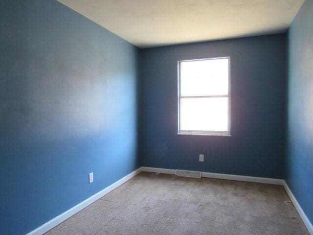 spare room featuring baseboards and carpet