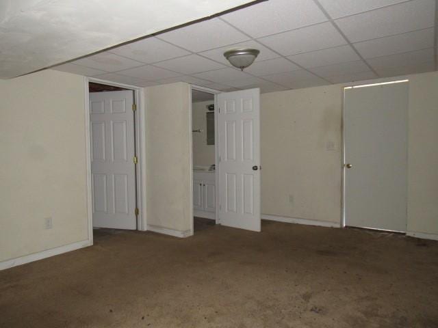 finished basement featuring a drop ceiling, baseboards, and carpet floors