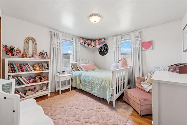 bedroom featuring multiple windows and wood finished floors