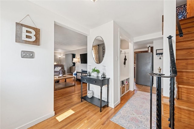 corridor featuring baseboards and wood finished floors