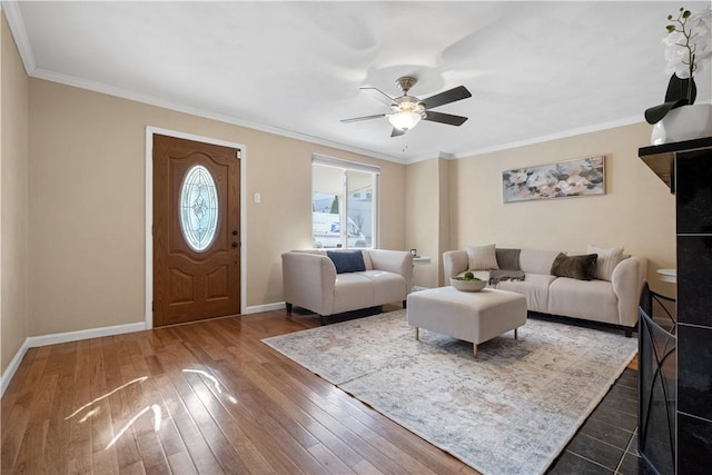 living area featuring ceiling fan, crown molding, baseboards, and dark wood-style flooring