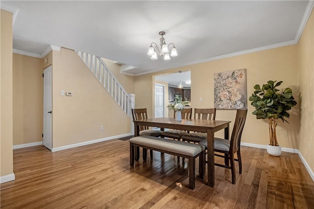 dining room with baseboards, wood finished floors, and crown molding