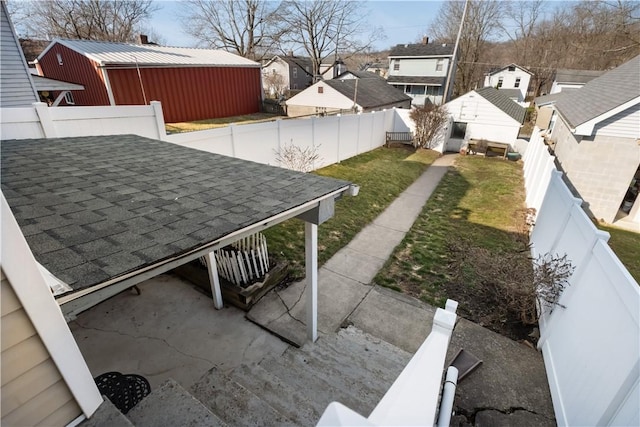 view of yard with an outbuilding, a fenced backyard, and a residential view