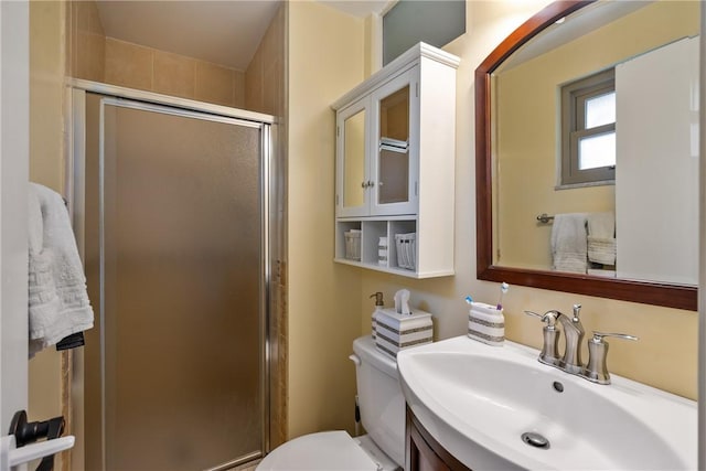 bathroom featuring a shower stall, toilet, and vanity