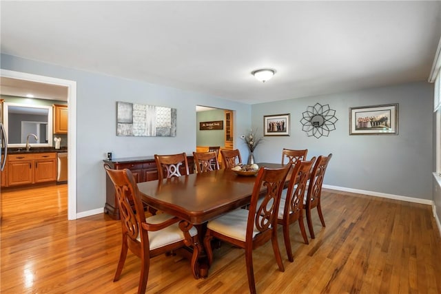 dining space featuring light wood-type flooring and baseboards