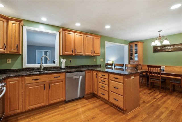 kitchen with a sink, dishwasher, a peninsula, and light wood finished floors