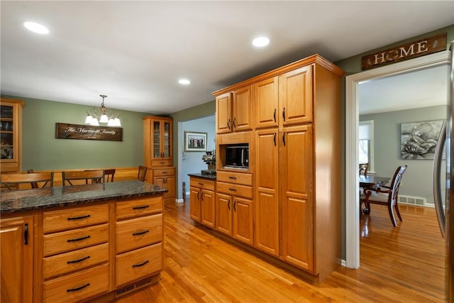 kitchen featuring light wood finished floors, visible vents, recessed lighting, and dark stone countertops