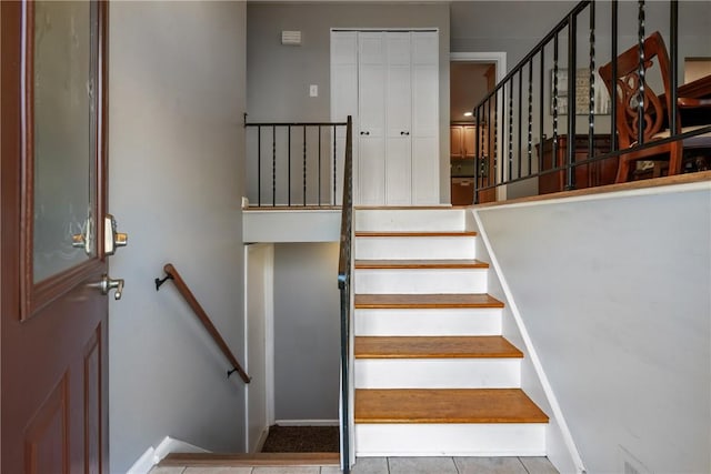 staircase featuring tile patterned flooring and baseboards