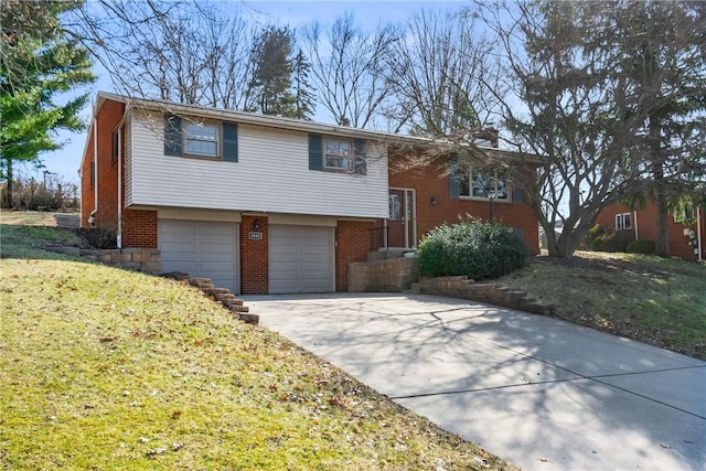 split foyer home with a garage, a front yard, brick siding, and driveway